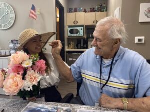 an senior man and a young woman in hat friendly interaction